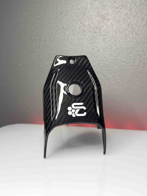 Carbon fiber part with a logo on a gray background